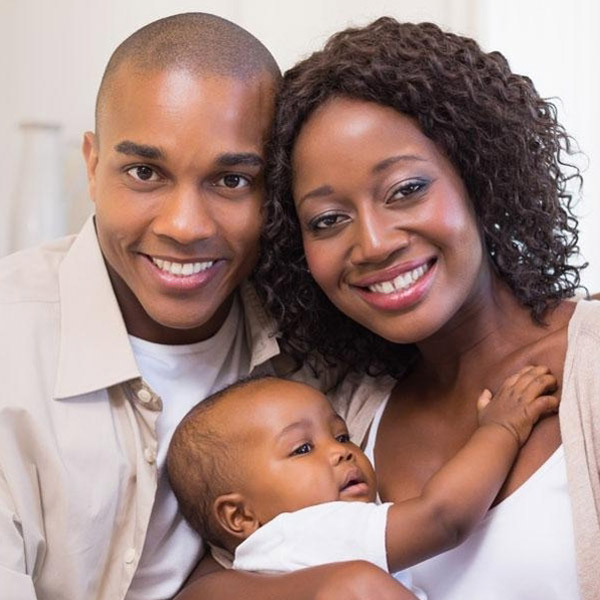 Happy family smiling showing their white teeth indoors