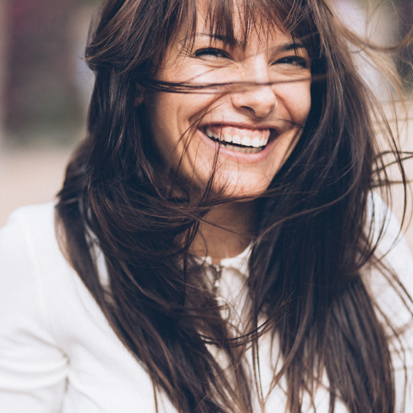 Woman smiling showing her white teeth outdoors
