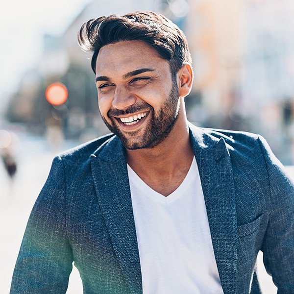 Man smiling showing his white teeth in the city