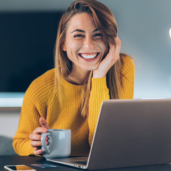 Woman smiling showing her white teeth working late