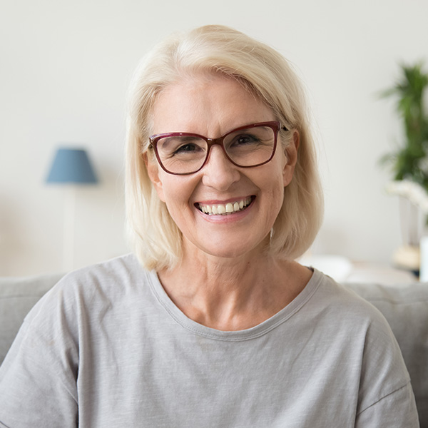 Woman smiling showing her white teeth wearing glasses