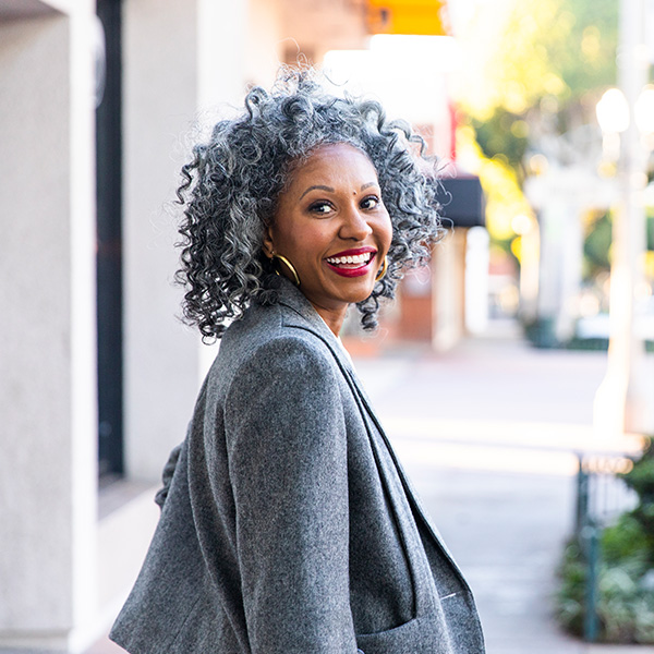 Woman smiling showing her white teeth walking down the street