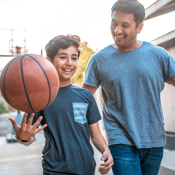 Father and son playing basketball outdoors