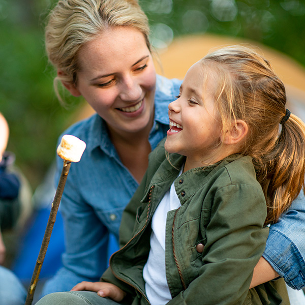 Mother and daughter eating marshmallows at the fire pit