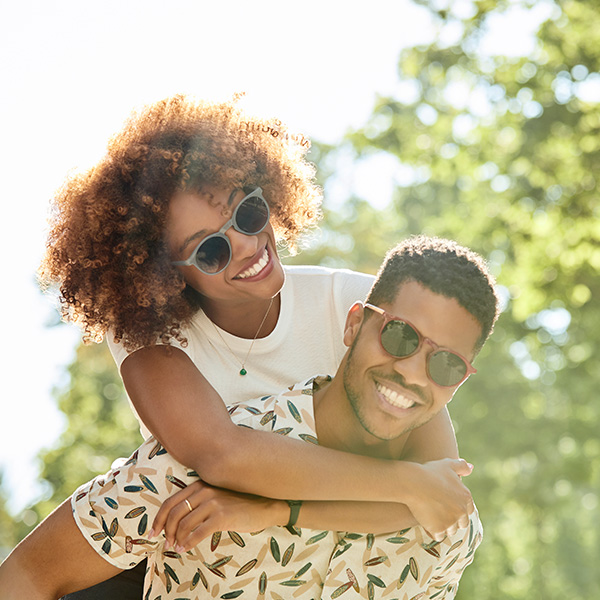 Happy couple smiling showing their white teeth in the park