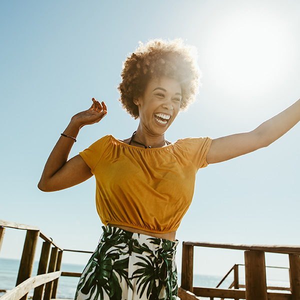 Woman smiling showing her white teeth at the beach