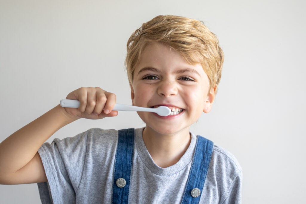 A kid brushing his teeth