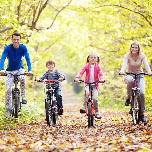 Happy family smiling cycling in the park