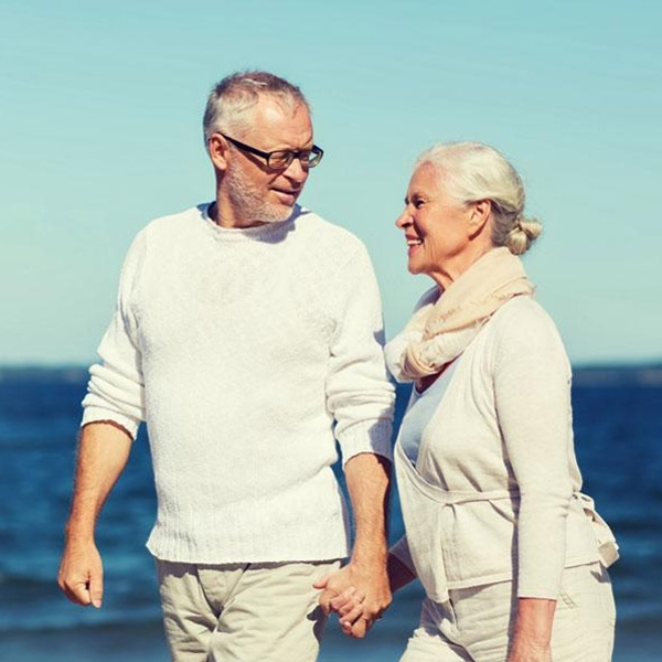 Couple walking on beach after getting dental crowns in North Phoenix, AZ