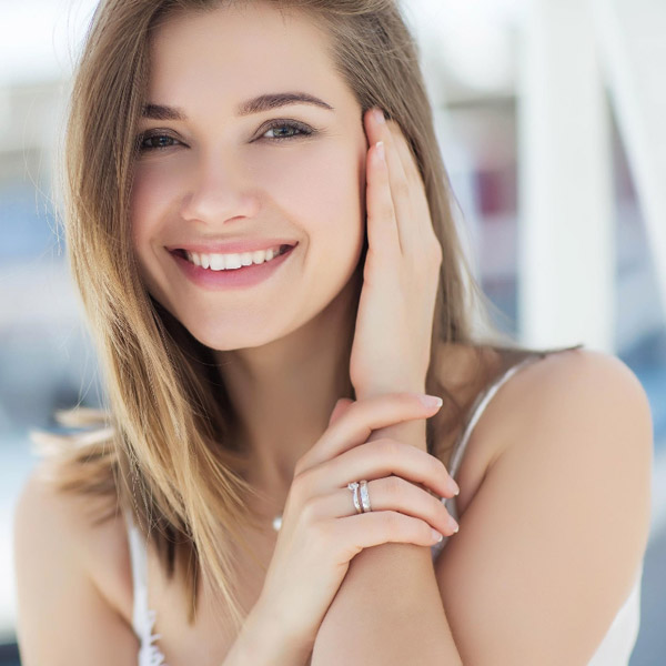 woman smiling touching her face