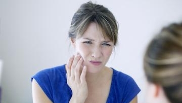 Young woman having teeth pain while chewing food in Northern Phoenix, AZ