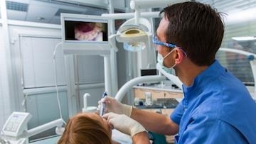 Dental doctor treating to his patient teeth