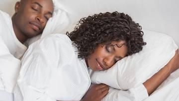 African couple sleeping on bed