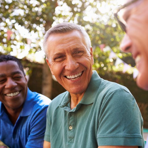 three elderly men smiling in park