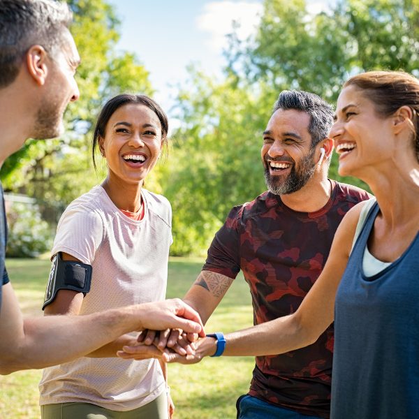 two middle age couples greeting in park