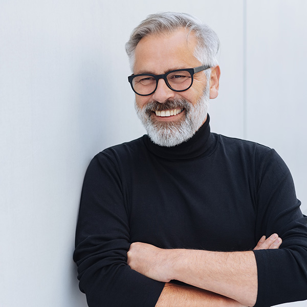 Happy man smiling showing his white teeth and wearing glasses