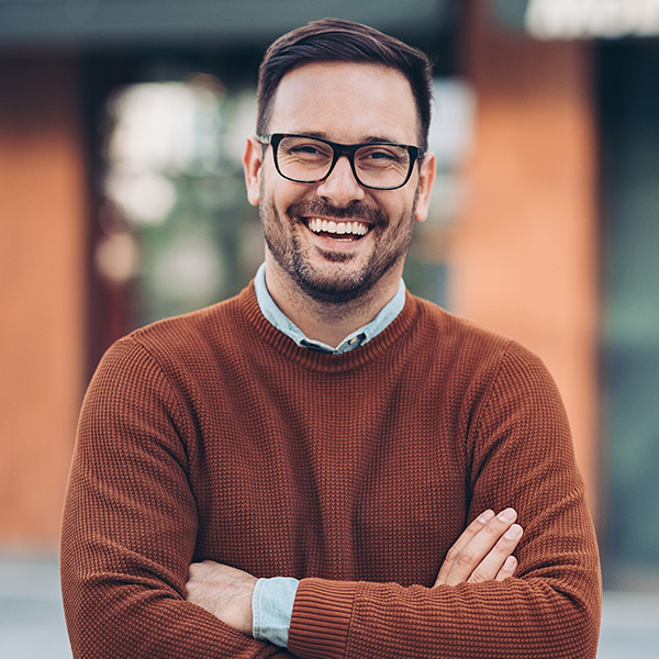 Man smiling showing his white teeth outdoors