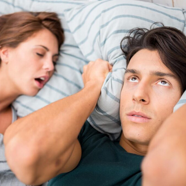 Man covering his ears because with pillow